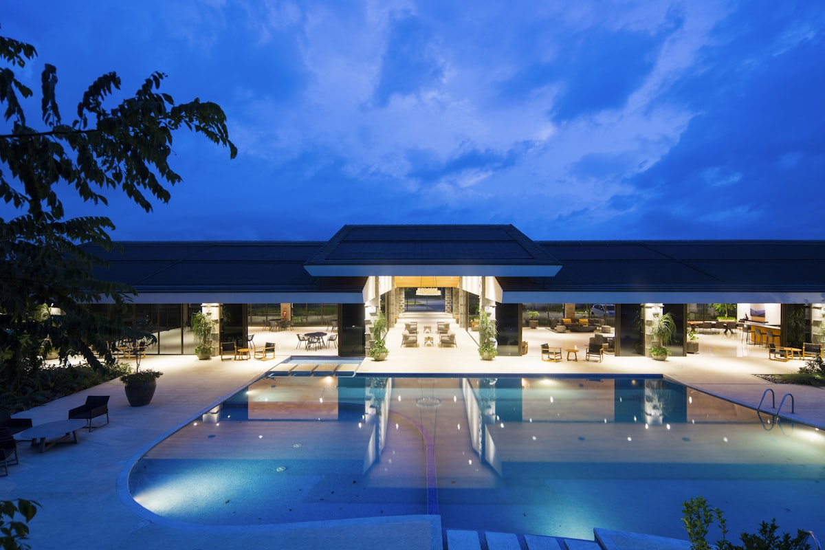 Modern hotel exterior with pool at twilight